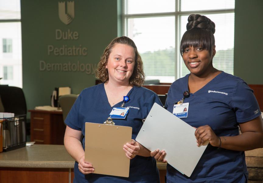 Two nurses holding clip boards